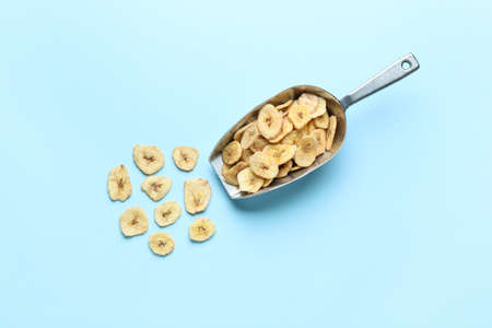 Scoop of crispy banana chips on color backgroundの写真素材