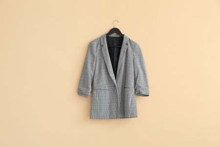 Hanger with jacket on color background