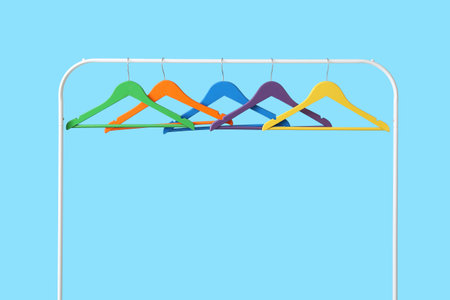 Rack with clothes hangers on color backgroundの写真素材