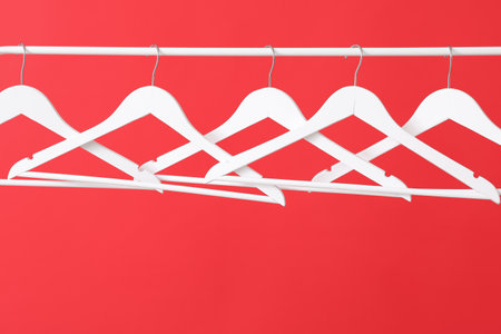 Rack with clothes hangers on color backgroundの写真素材