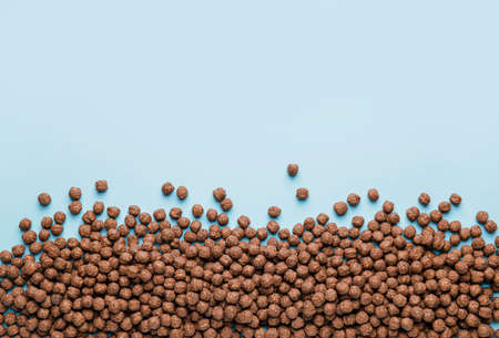 Tasty chocolate corn balls on color background
