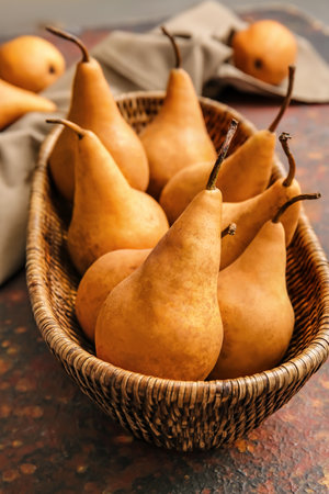 Basket with fresh ripe pears on grunge backgroundの写真素材