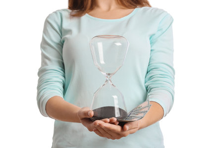 Young woman with hourglass and money on white backgroundの写真素材