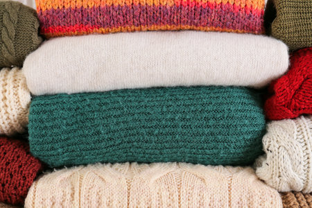 Stack of warm winter clothes as background