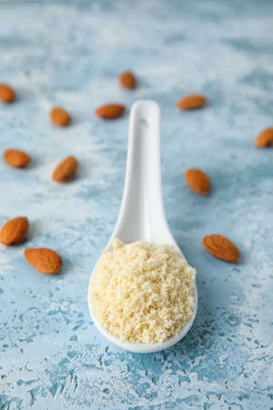 Spoon with almond flour on color backgroundの写真素材