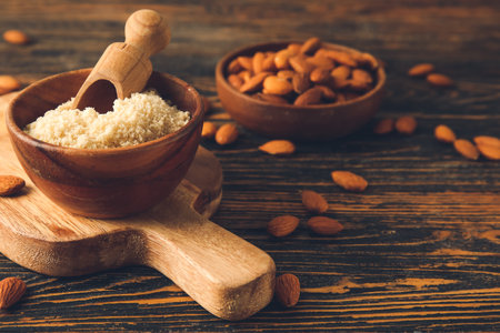 Bowl and scoop with almond flour on wooden backgroundの写真素材