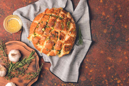 Composition with garlic bread and herbs on grunge background