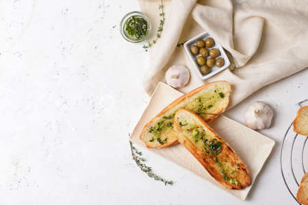 Toasted bread with garlic and olives on light backgroundの写真素材