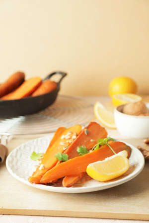 Plate of tasty baked carrot on tableの写真素材