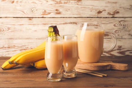 Glasses with tasty banana juice on wooden backgroundの写真素材