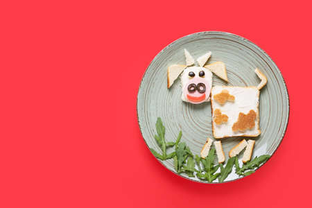 Plate with tasty sandwich in shape of bull on color backgroundの写真素材