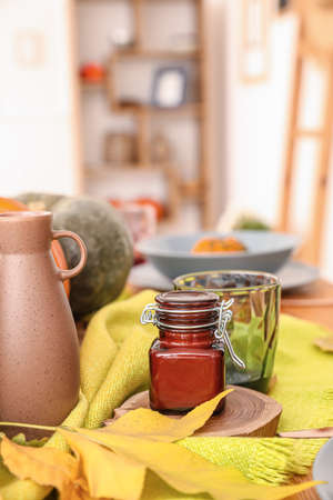 Beautiful table setting with autumn leaves in dining roomの写真素材