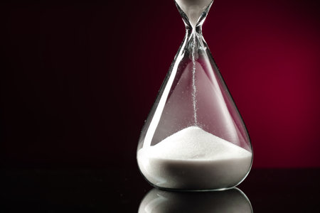 Hourglass on dark color background. Time management concept