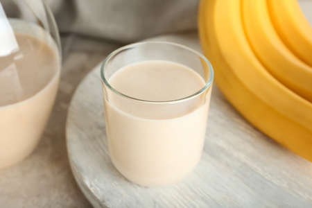 Glass of tasty banana smoothie on tableの写真素材