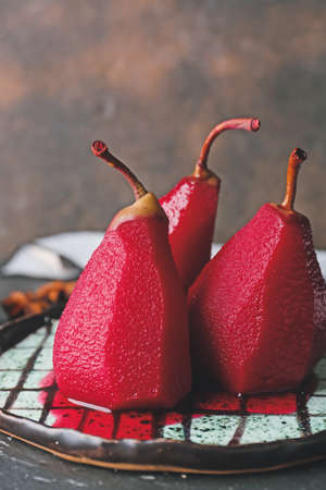 Plate with sweet poached pears in red wine on grunge background, closeupの写真素材