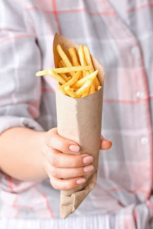 Woman with tasty french fries, closeup