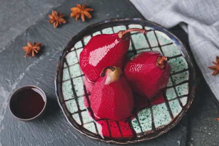 Plate with sweet poached pears in red wine on dark backgroundの写真素材