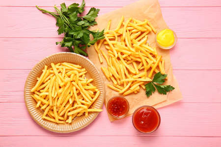 Tasty french fries with sauces on table
