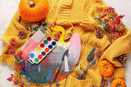 Autumn composition with stylish clothes and painter's supplies on light backgroundの写真素材