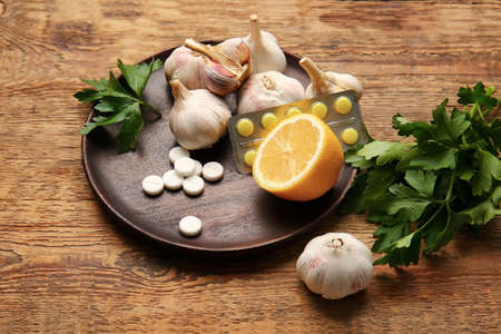 Plate with healthy products and pills on wooden backgroundの写真素材