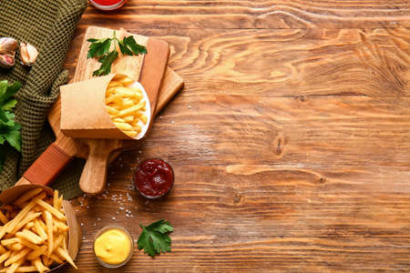 Tasty french fries and sauces on table