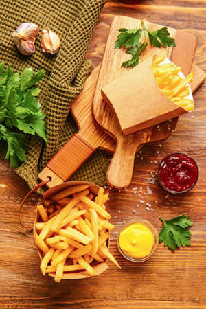 Tasty french fries and sauces on table