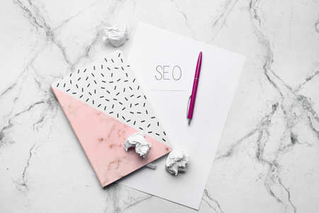 Paper sheet with abbreviation SEO and stationery on white backgroundの写真素材