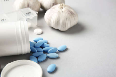 Fresh garlic with pills on light backgroundの写真素材