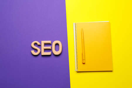 Abbreviation SEO with notebook and pen on color backgroundの写真素材