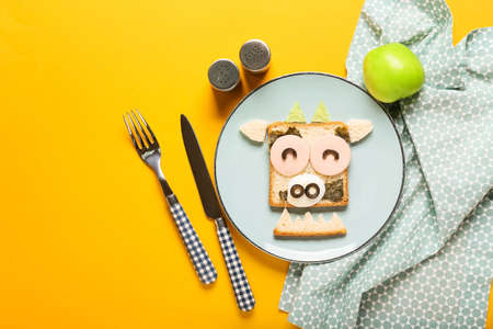 Plate with tasty sandwich in shape of bull on color backgroundの写真素材