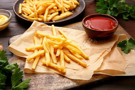 Tasty french fries with tomato sauce on tableの写真素材