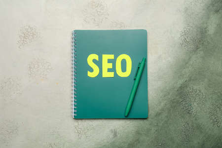 Abbreviation SEO with notebook and pen on color backgroundの写真素材