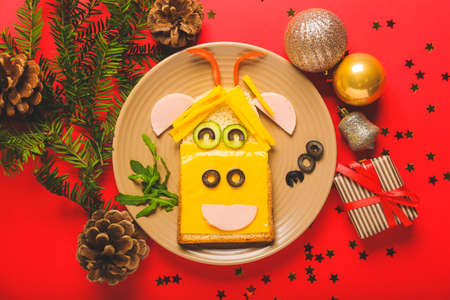 Tasty sandwich in shape of bull and New Year decor on color backgroundの写真素材