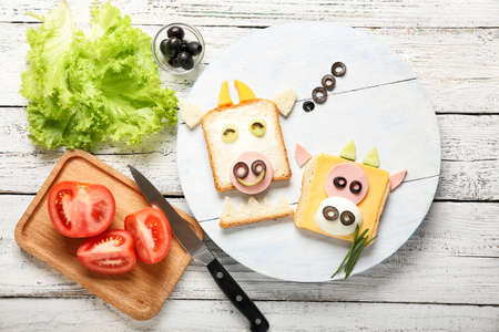 Board with tasty sandwiches in shape of bull on tableの写真素材