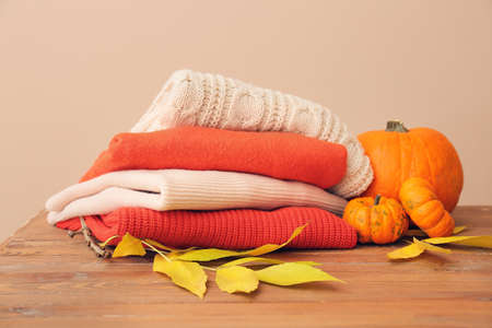 Autumn composition with stylish clothes on table against color backgroundの写真素材