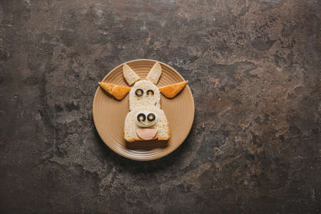 Plate with tasty sandwich in shape of bull on dark backgroundの写真素材