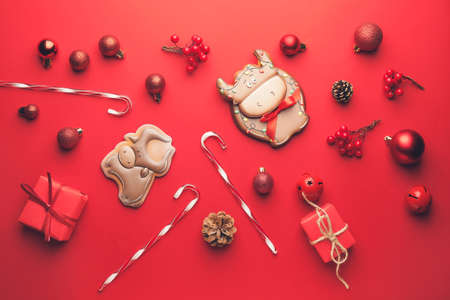 Tasty cookies in shape of bull and Christmas decor on color background