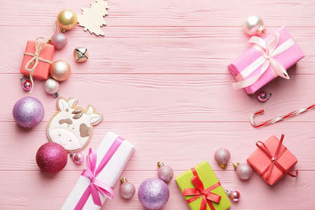 Tasty cookie in shape of bull, gifts and Christmas decor on color wooden backgroundの写真素材