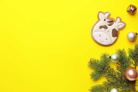 Tasty cookie in shape of bull and Christmas decor on color backgroundの写真素材