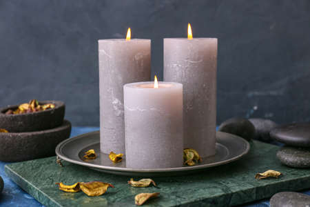 Beautiful aroma candles with spa stones on tableの写真素材