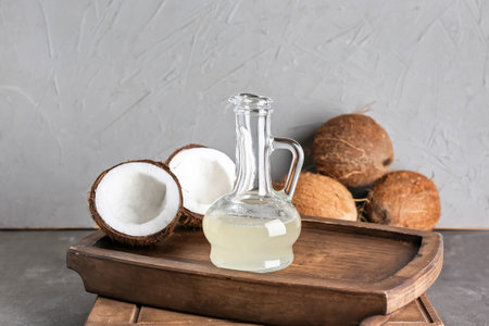 Tray with decanter of coconut oil on dark backgroundの写真素材