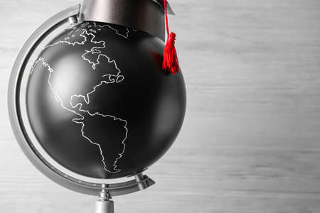 Globe with graduation hat on light backgroundの写真素材
