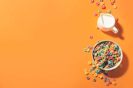 Bowl with tasty cereal rings and milk on color backgroundの写真素材