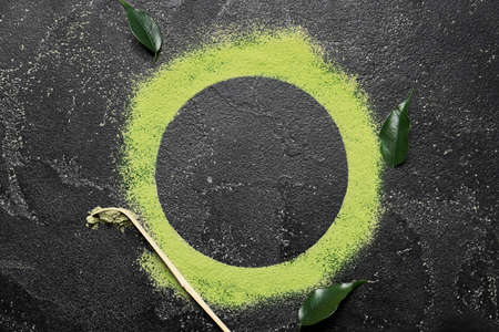 Frame made of powdered matcha tea and chashaku on dark backgroundの写真素材