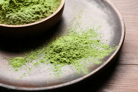 Bowl with powdered matcha tea on wooden background, closeupの写真素材