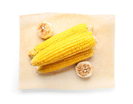 Tasty grilled corn cobs and garlic on white background
