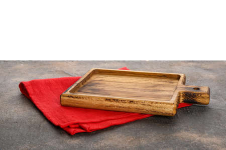 Wooden cutting board on grunge table against white background