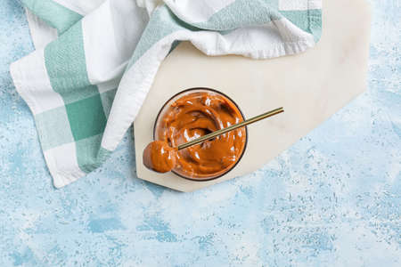 Bowl of boiled condensed milk on color backgroundの写真素材