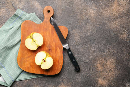Wooden cutting board and cut apple on grunge backgroundの写真素材