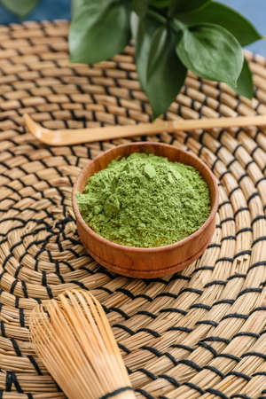 Bowl with powdered matcha tea, chasen and chashaku on table